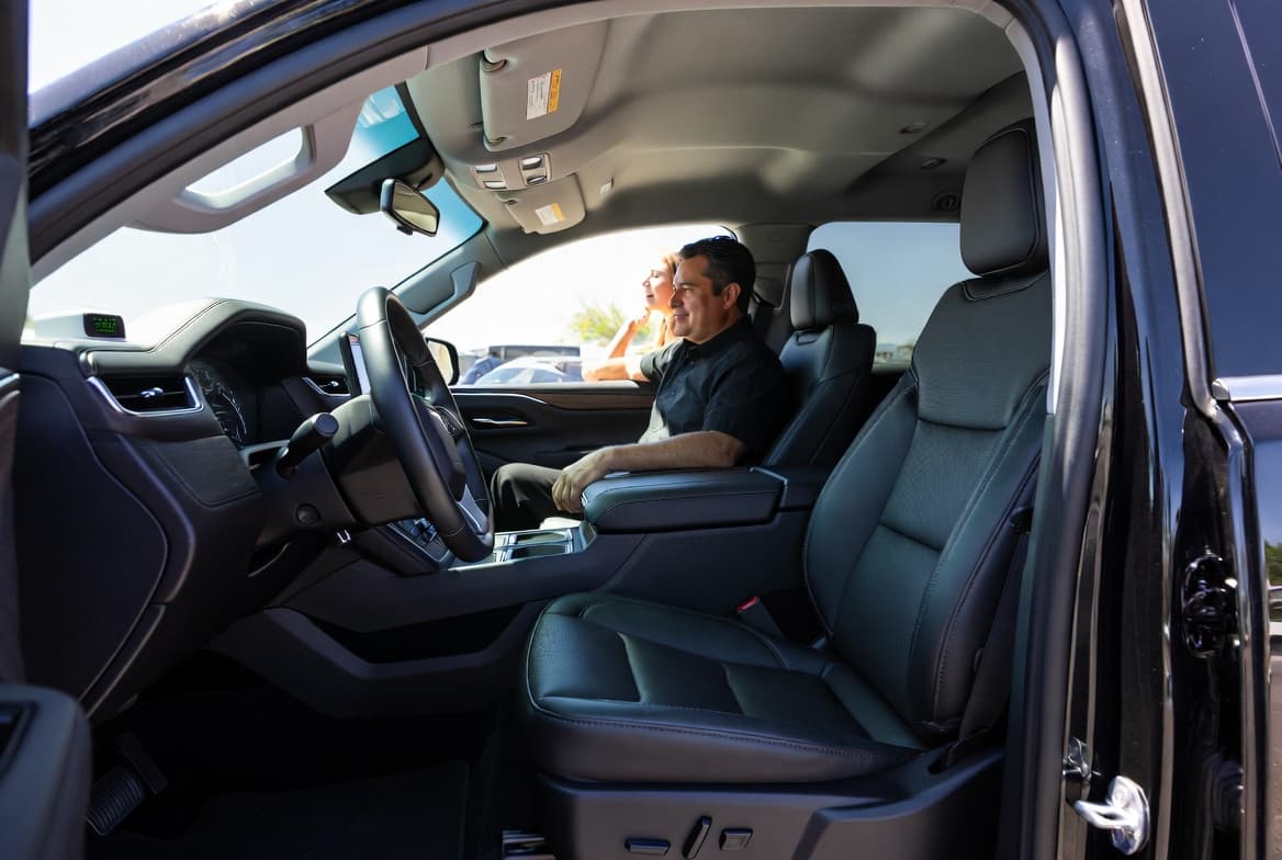 Customer inspecting a freshly treated SUV interior after professional car odor removal service